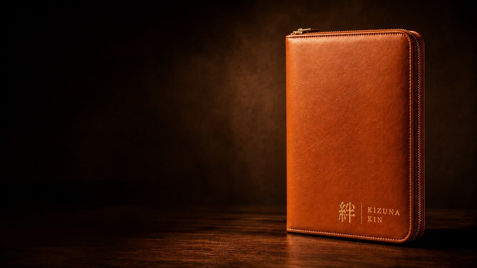 Kizuna Kin tan leather binder with gold 絆 emboss on a dark vault background
